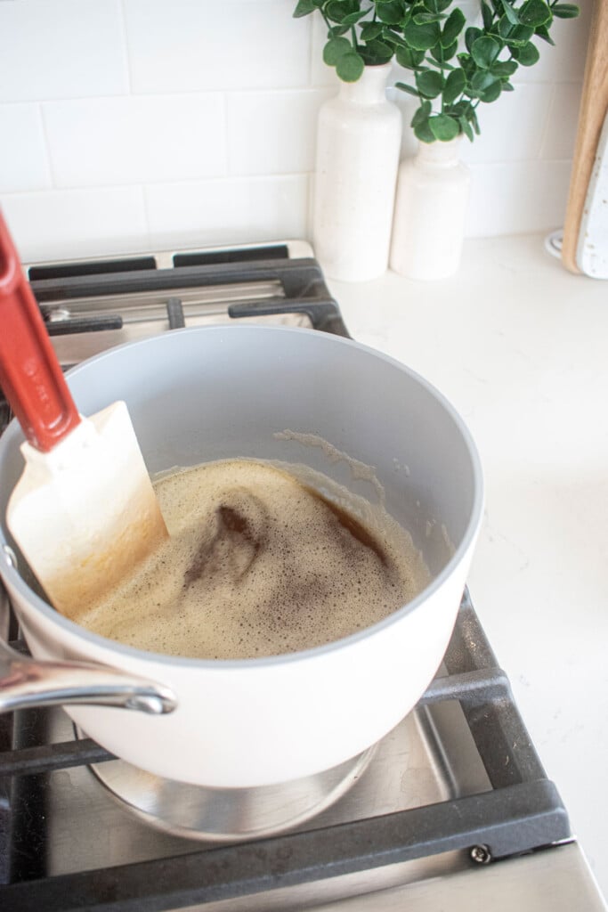 brown butter being stirred in a small pot on the stovetop.