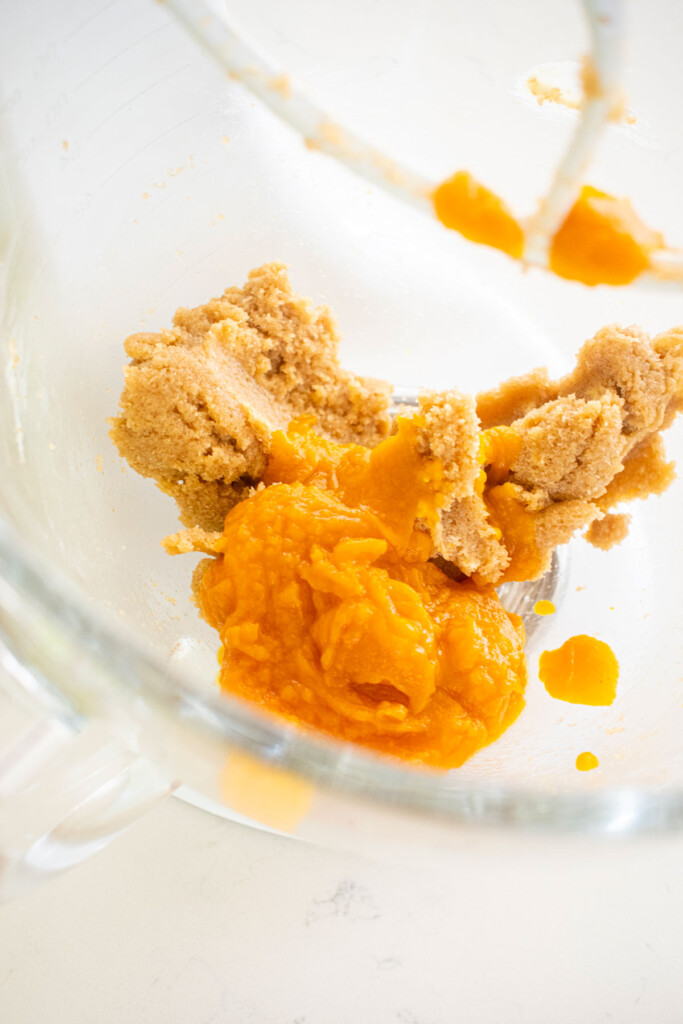 creamed butter and light brown sugar with pumpkin puree in a glass mixing bowl.