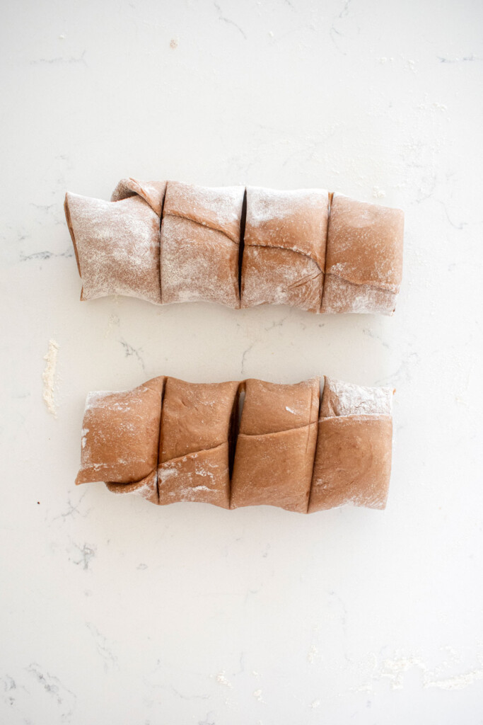 cut hot chocolate sweet rolls on a white marble counter.