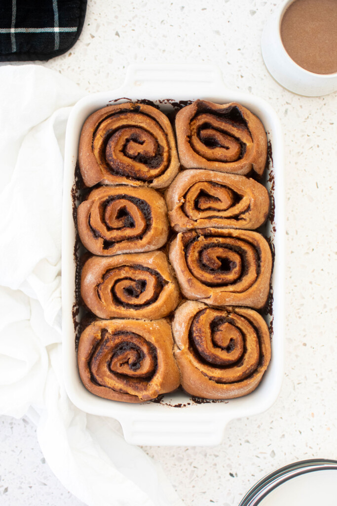hot chocolate sweet rolls in a white baking dish on a white marble counter.