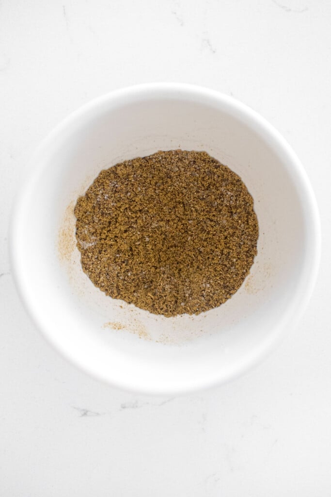 spices mixed together in a bowl on a white marble counter.