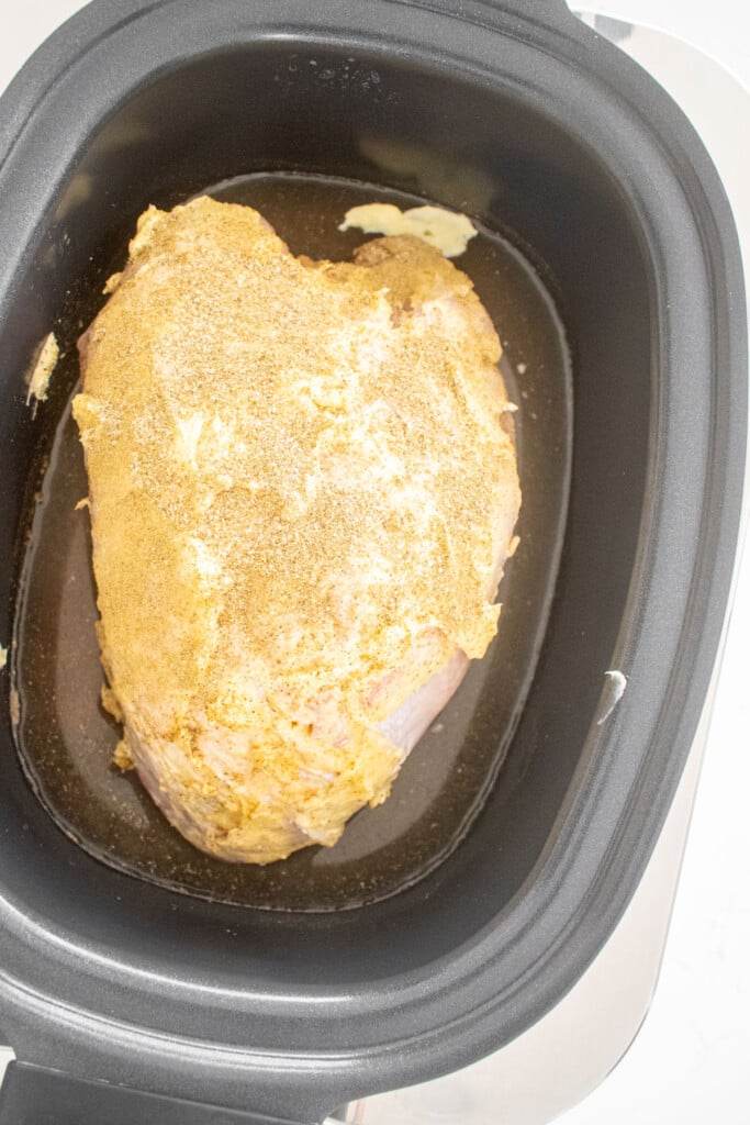 bone in turkey breast in a slow cooker with butter and spices rubbed on it.