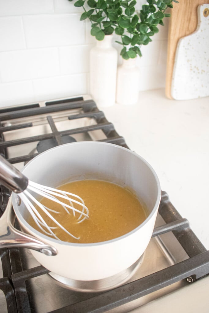 gravy being cooked in a small pot on the stovetop.