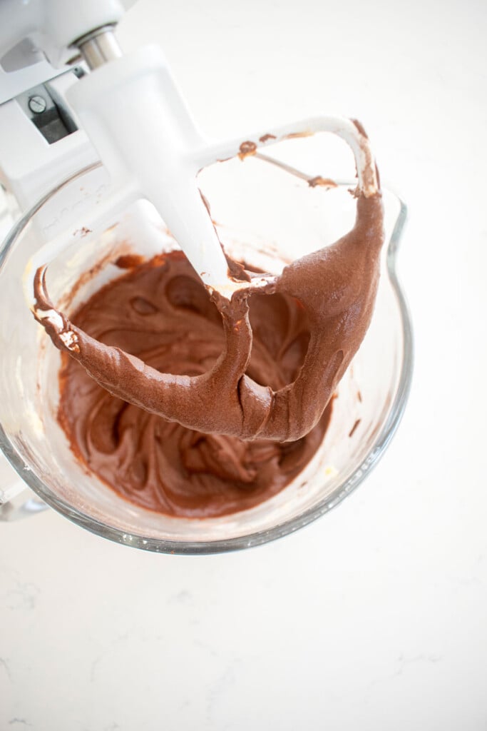 chocolate peppermint cupcake batter in a glass mixing bowl on a marble counter.