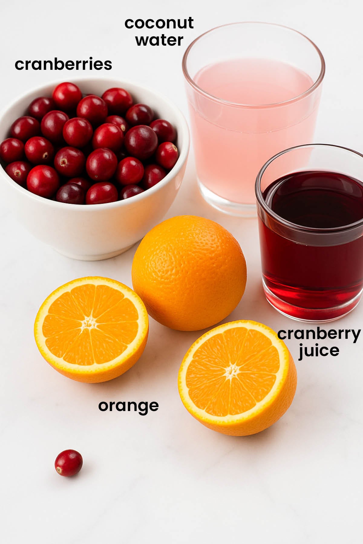 individual ingredients for cranberry mocktail with coconut water laid out against a white background.