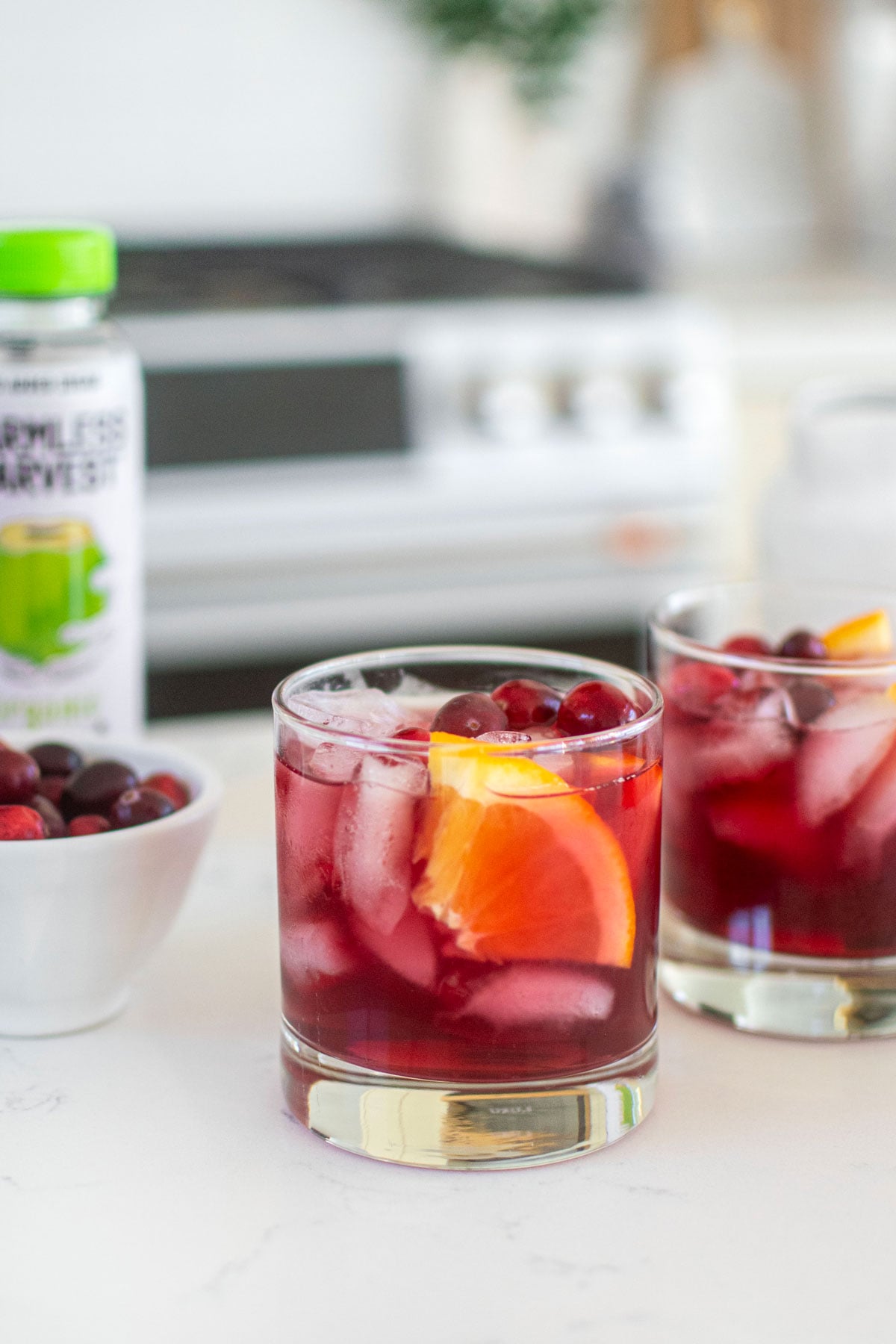 cranberry mocktail with coconut water on a white kitchen counter.