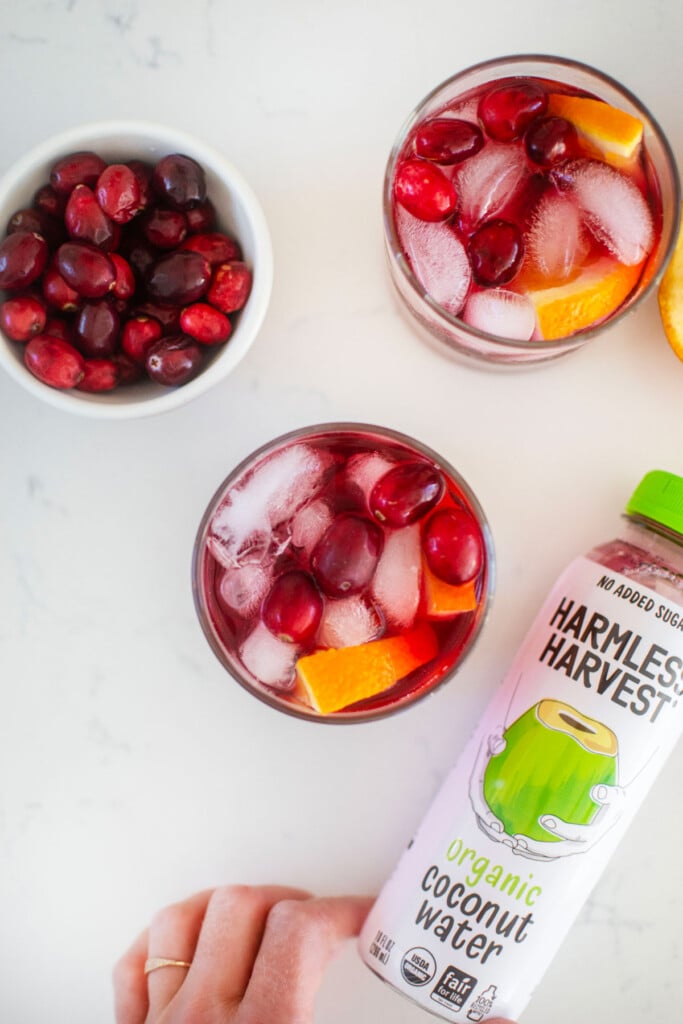 cranberry mocktail with coconut water on a white kitchen counter.