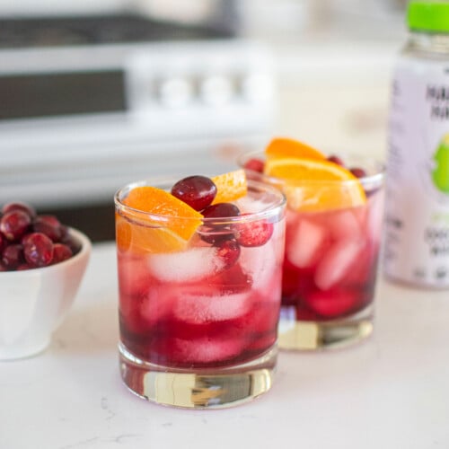 cranberry mocktail with coconut water on a white kitchen counter.