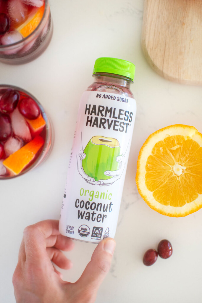cranberry mocktail with coconut water on a white kitchen counter.