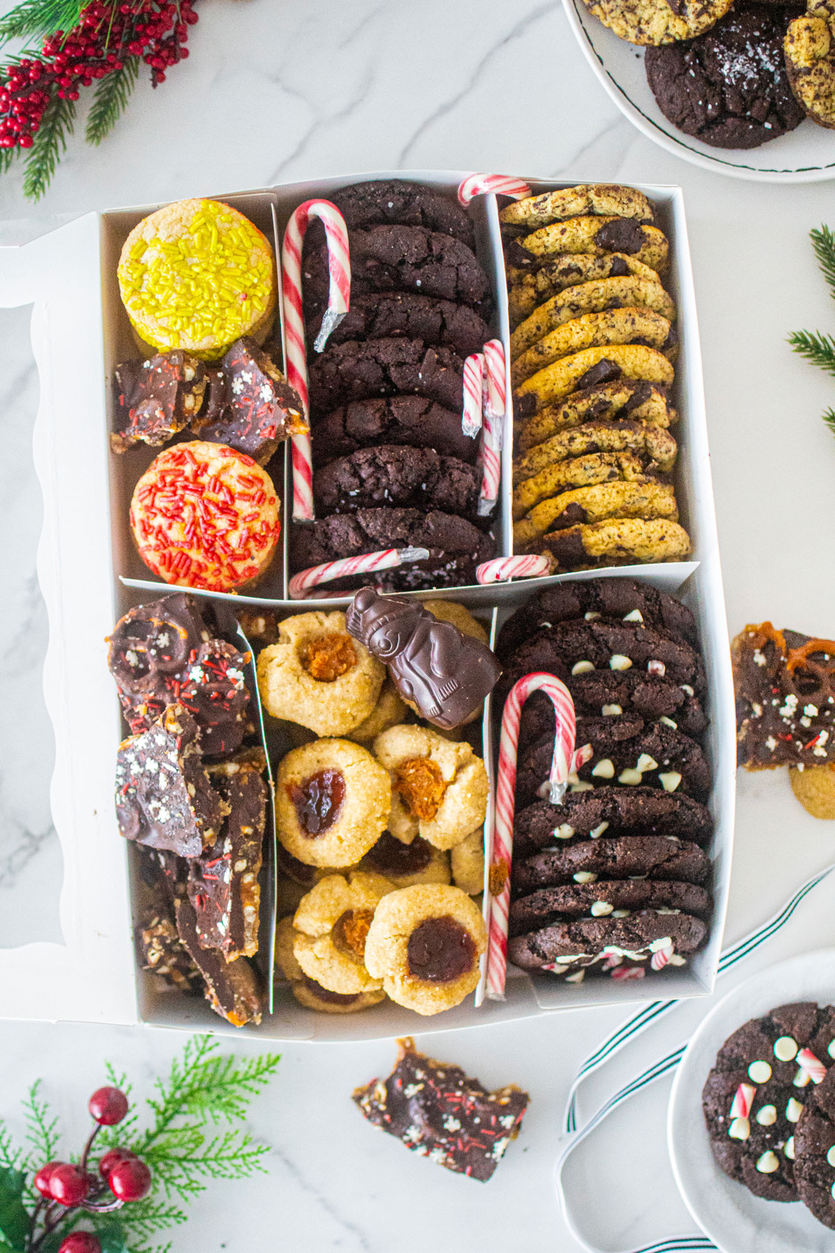 diy christmas cookie box with separators and different cookies in each slot on a marble counter.
