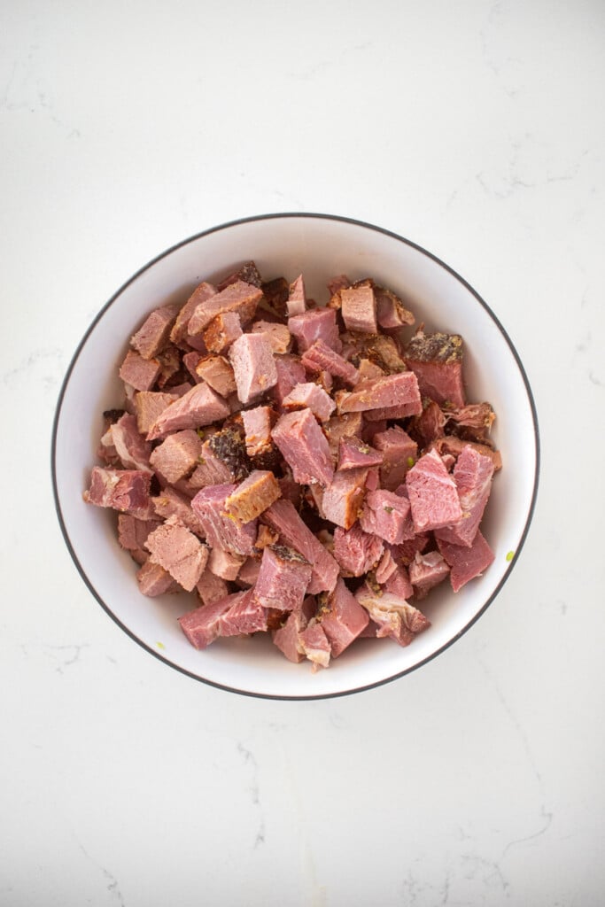 diced ham in a bowl on a marble countertop.