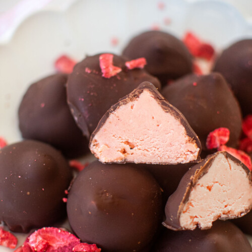 plate of strawberry cream drops on a white marble counter.