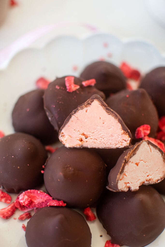 plate of strawberry cream drops on a white marble counter.