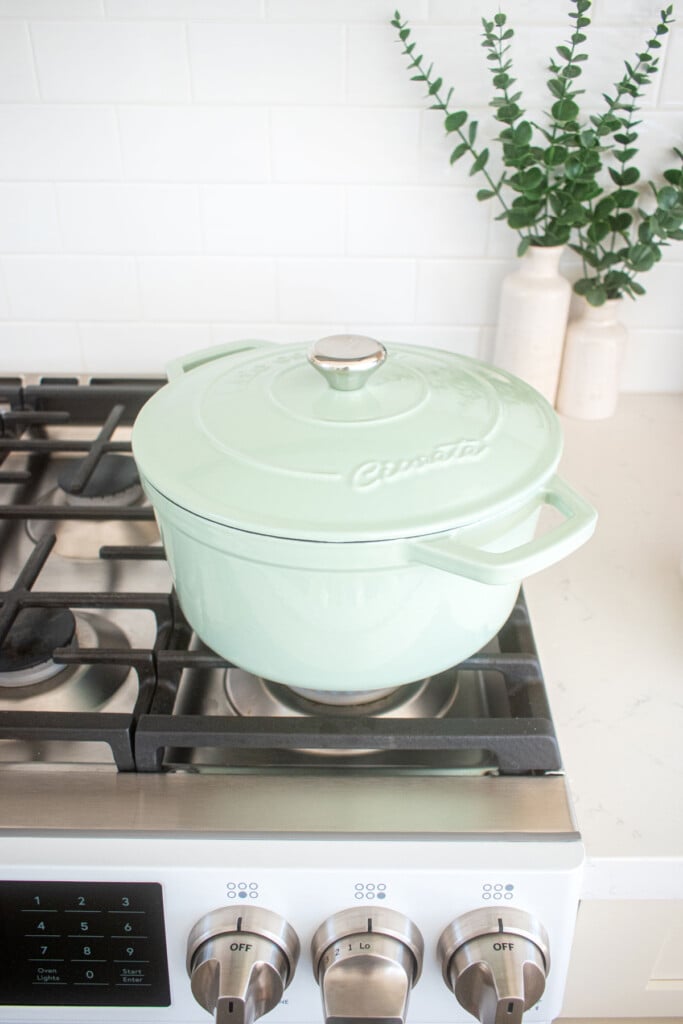 green dutch oven on the stovetop with a lid.