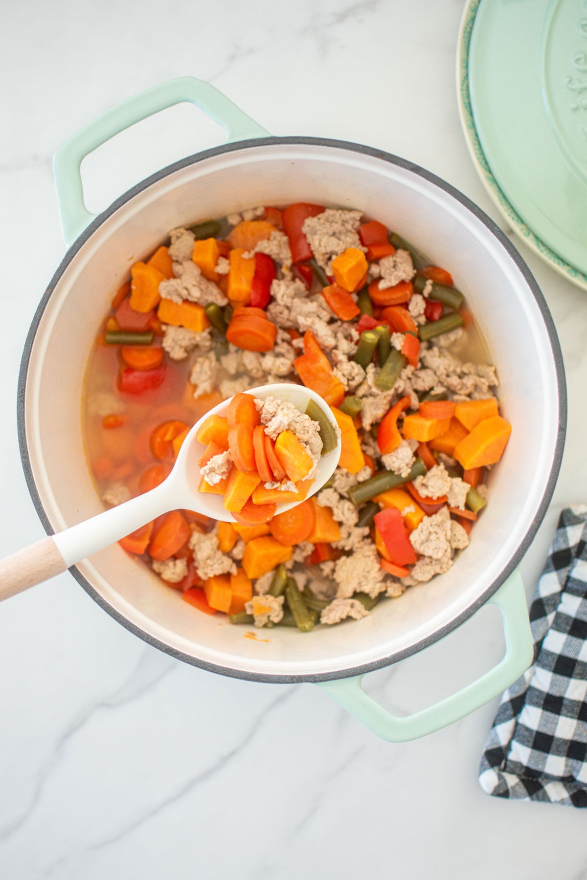 homemade turkey dog food recipe in a dutch oven on a white countertop.