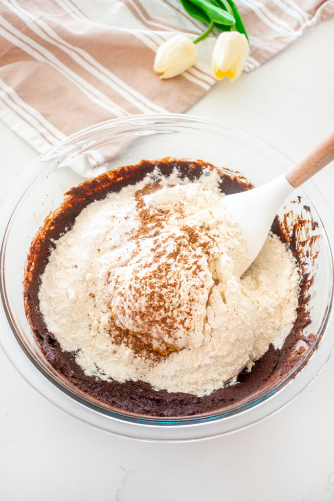 dry ingredients for bone broth brownies in a glass mixing bowl on a white marble counter.