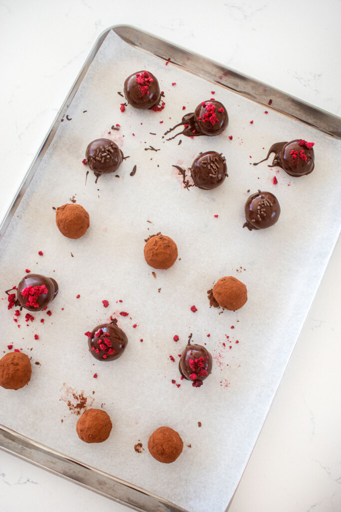 dark chocolate raspberry truffles on a baking sheet.