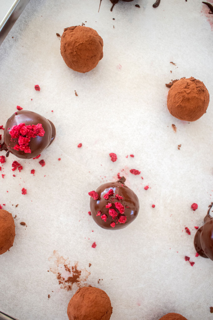 dark chocolate raspberry truffles on a baking sheet.