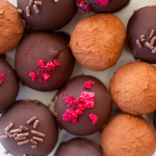 dark chocolate raspberry truffles on a white parchment paper.