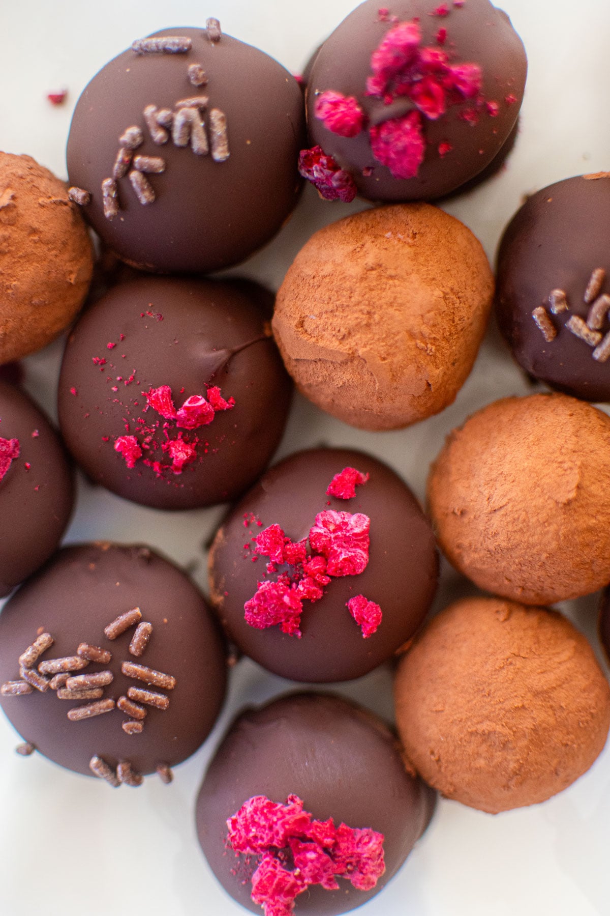 dark chocolate raspberry truffles on a white parchment paper.