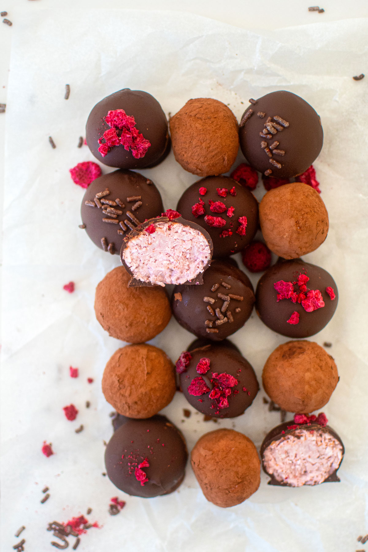 dark chocolate raspberry truffles on a white parchment paper.