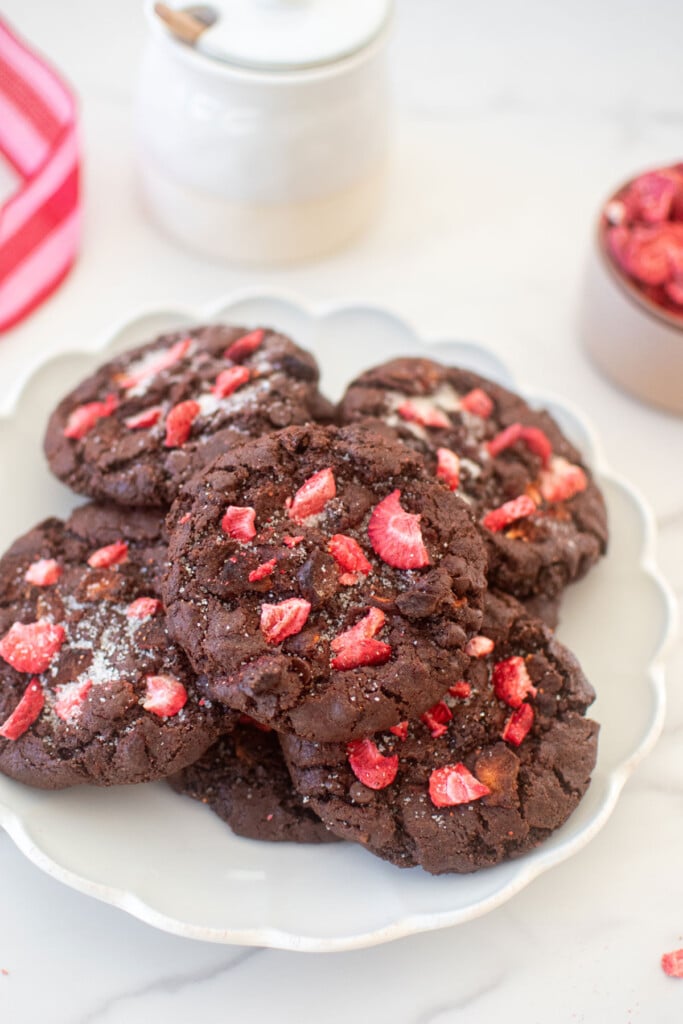 plate of eggless chocolate strawberry cookies on a white marble counter.
