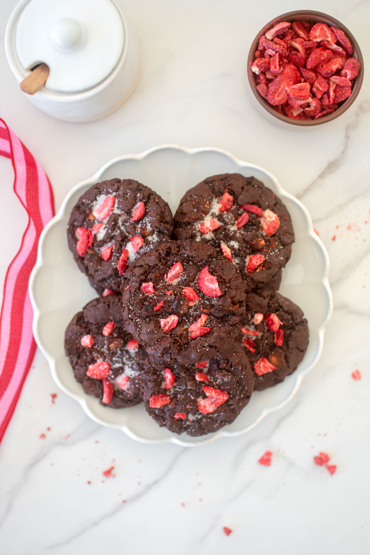 plate of eggless chocolate strawberry cookies on a white marble counter.