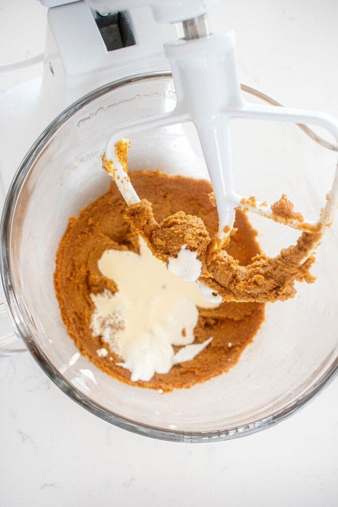 ingredients for eggless cosmic brownie cookie dough in a glass mixing bowl on a marble counter.