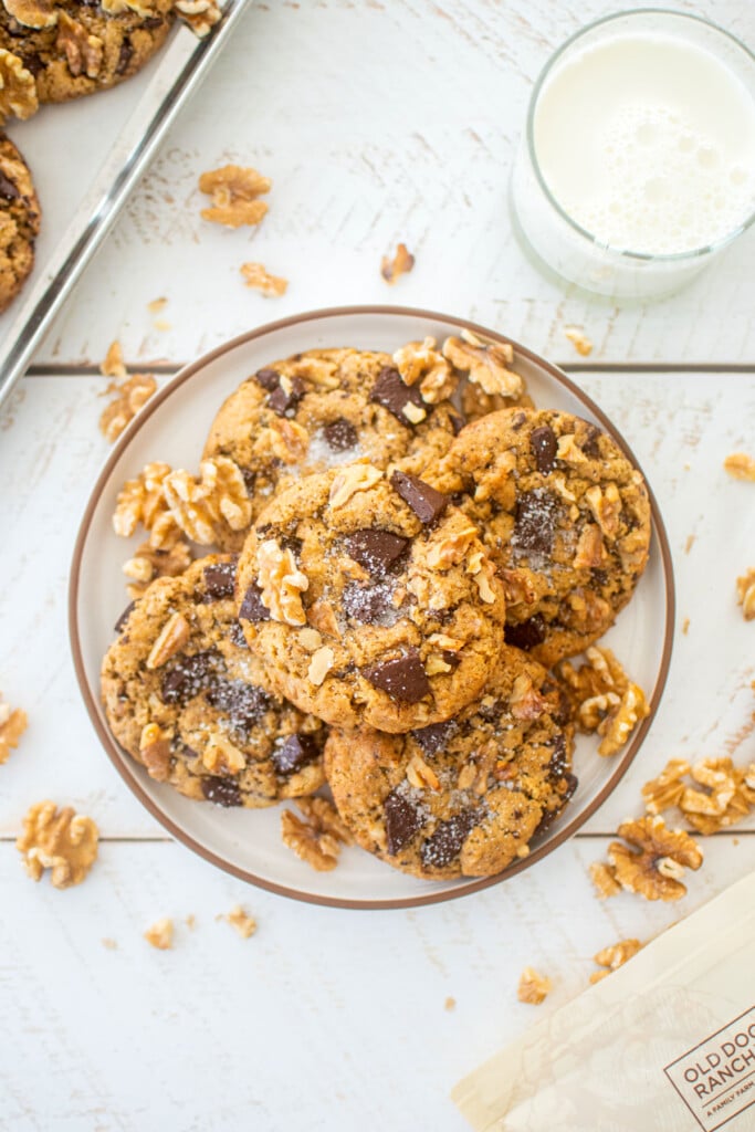 espresso walnut chocolate chip cookies on a plate with a glass of milk.