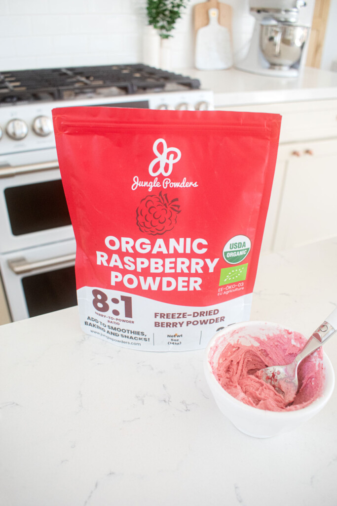pink frosting with freeze dried raspberry powder on a white marble counter.