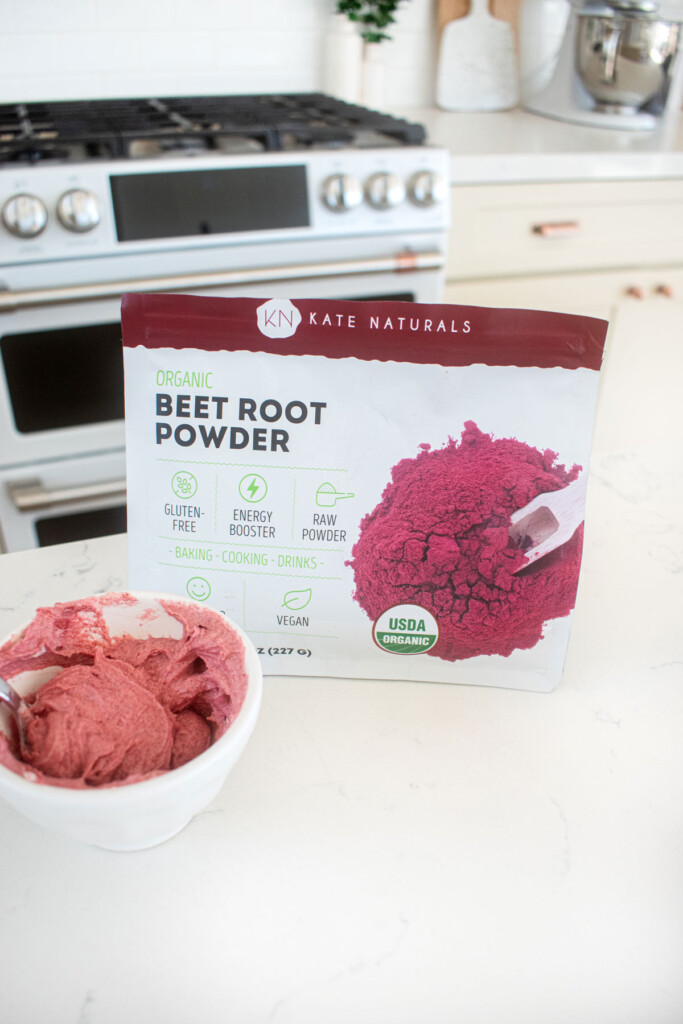 pink frosting with beet powder on a white marble counter.