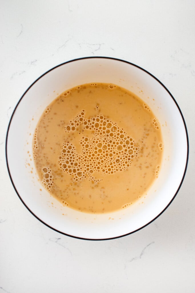 yeast, brown sugar and sourdough discard in a bowl on a marble countertop.