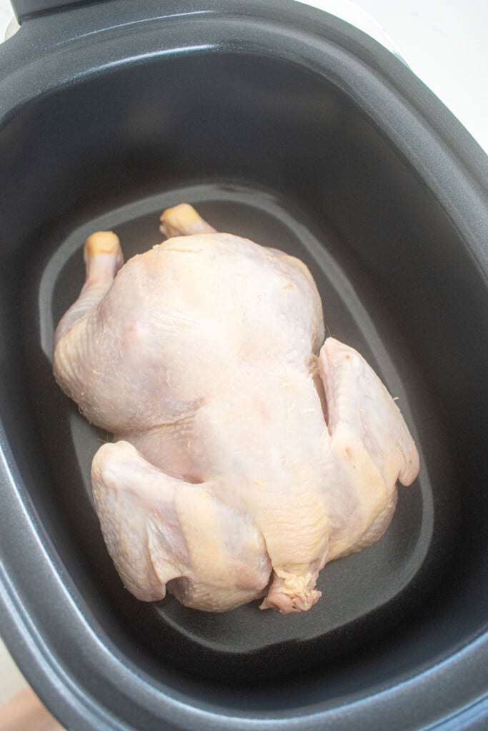 raw whole chicken in a slow cooker.