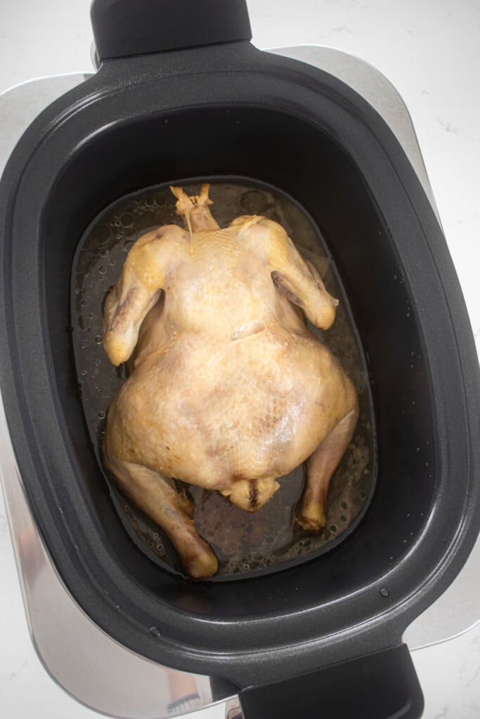 cooked whole chicken in a slow cooker.