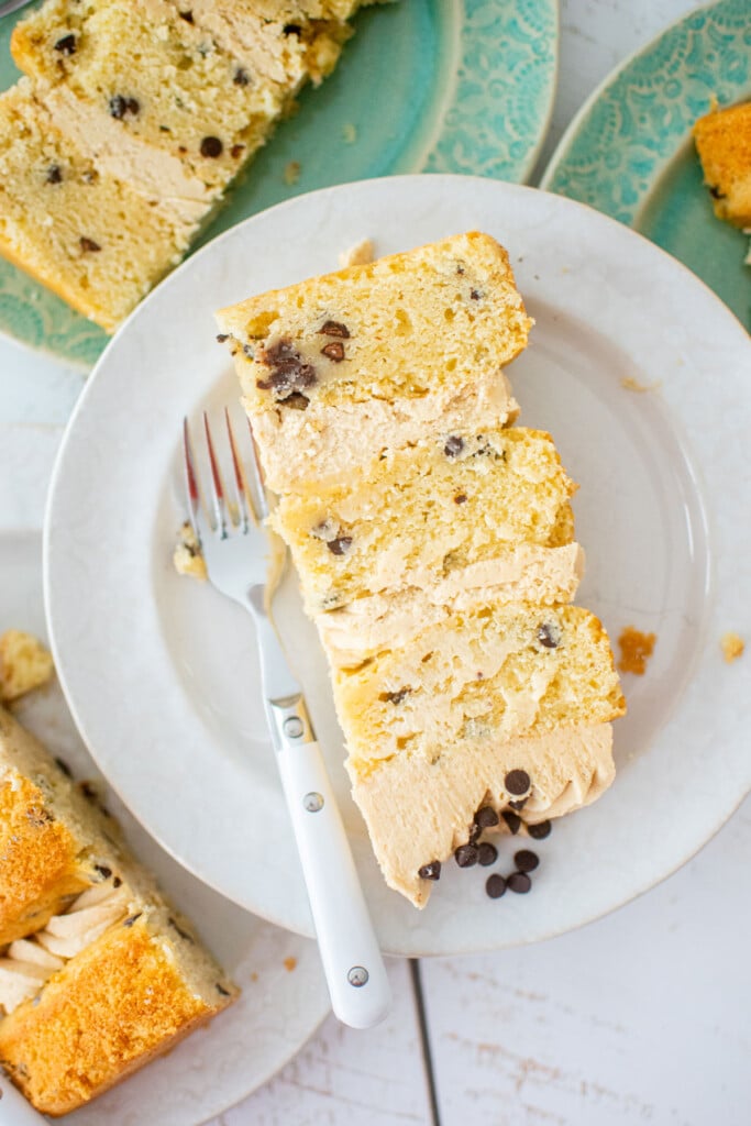 slice of cookie dough layer cake on a cake plate with a fork.