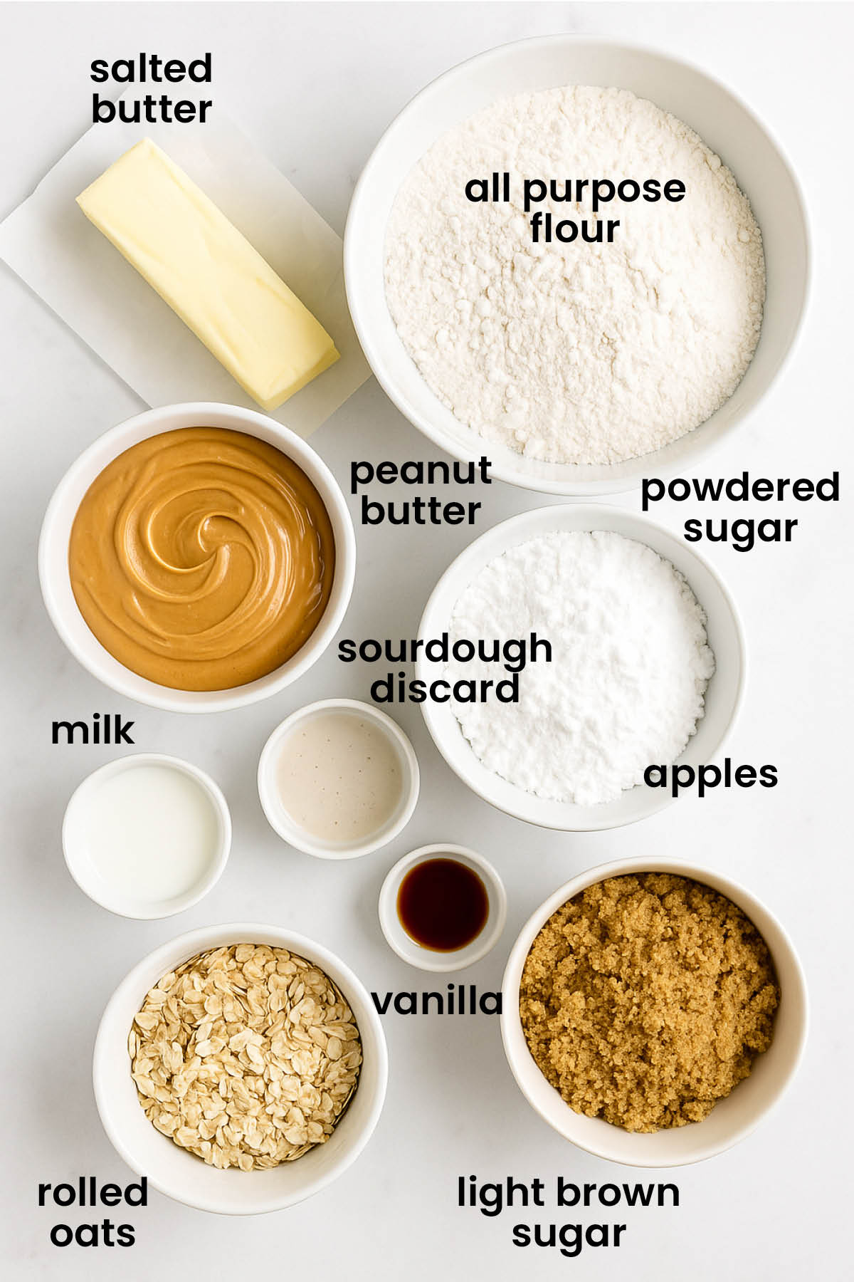 individual ingredients for peanut butter oatmeal sandwich cookies with sourdough discard laid out against a white background.