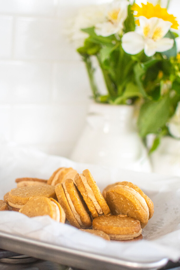 peanut butter oatmeal sandwich cookies with sourdough discard on a baking sheet on the oven.