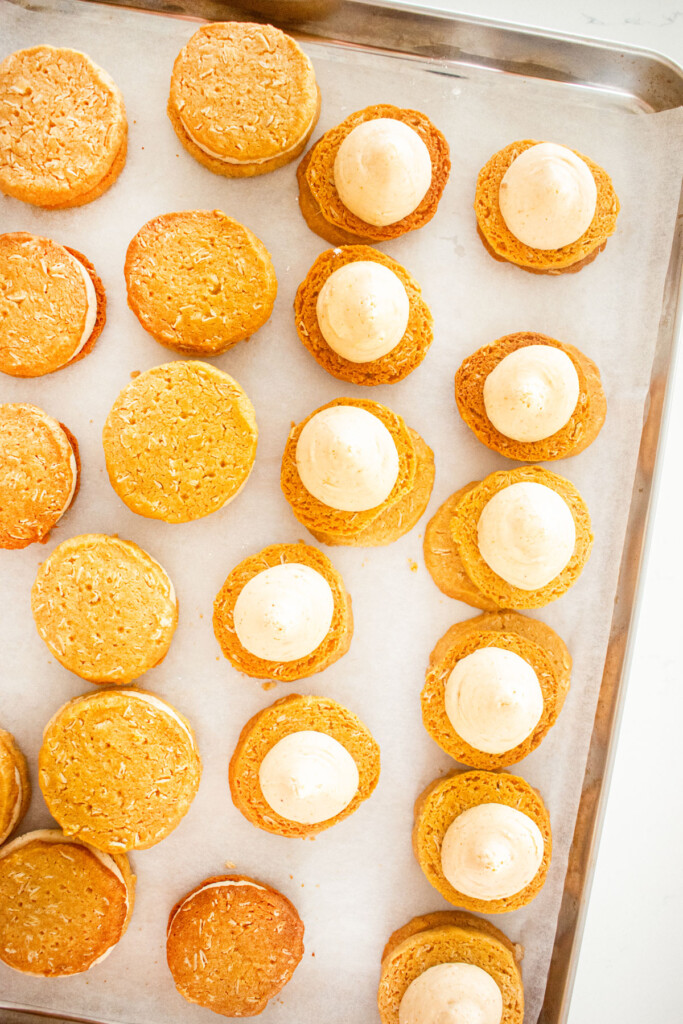 peanut butter oatmeal cookies with peanut butter filling on a baking sheet.