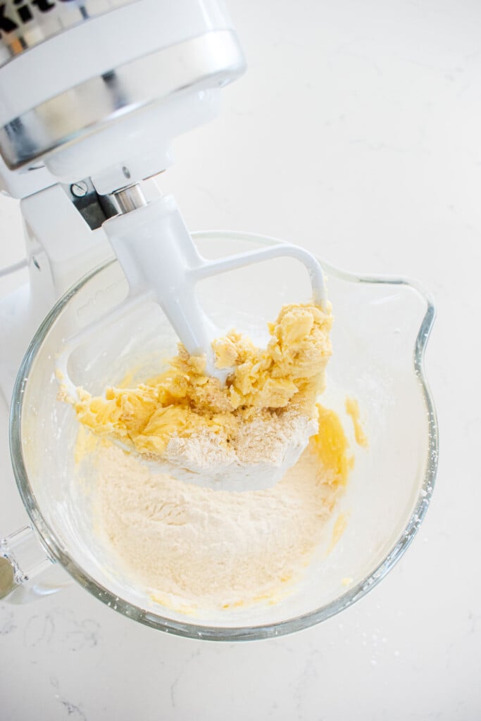 ingredients for homemade tagalong cookie dough in a glass mixing bowl on a marble counter.