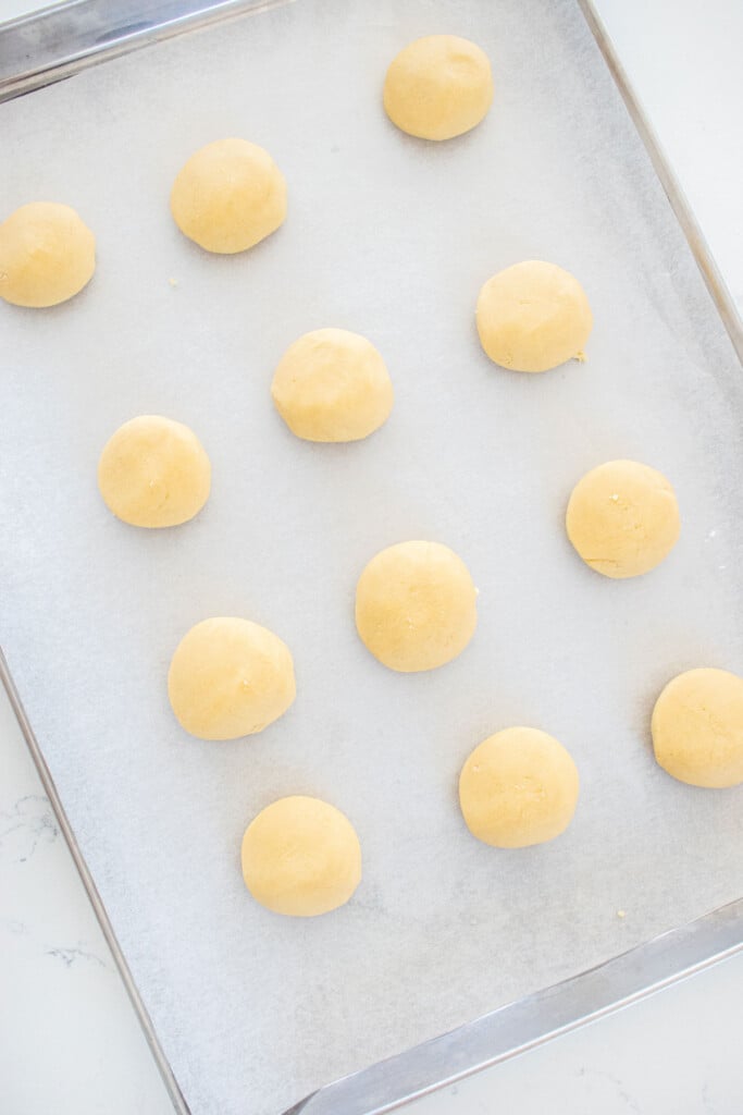 homemade tagalong cookie dough balls on a baking sheet on a marble counter.