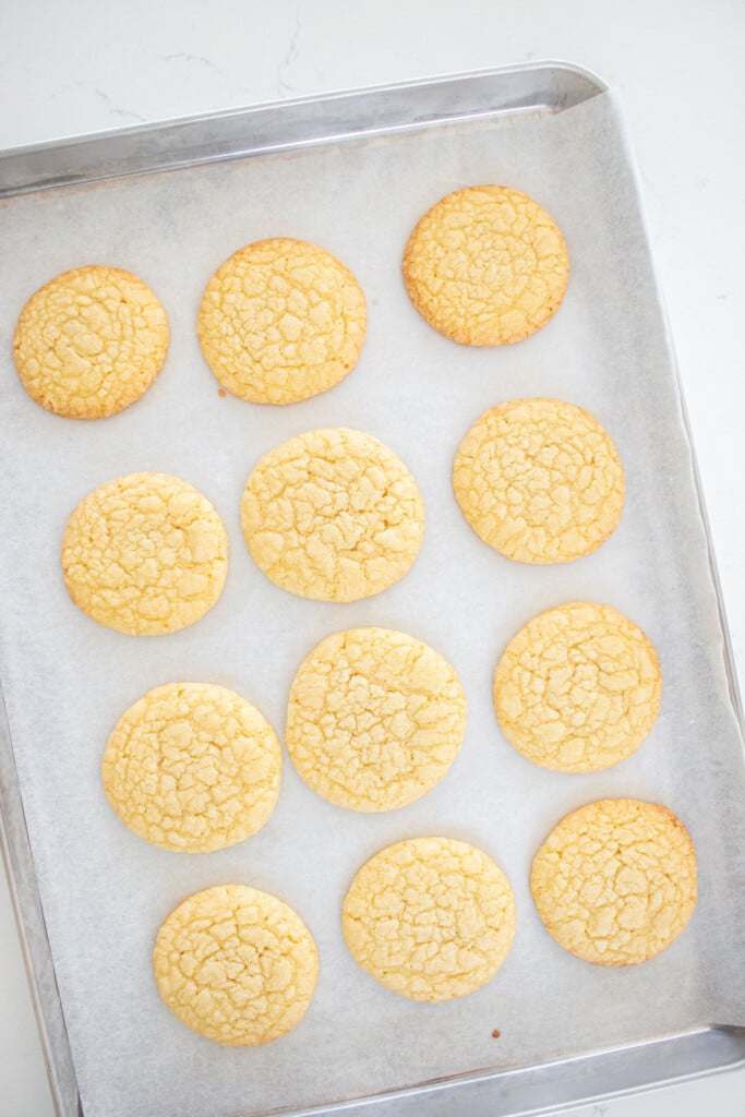 homemade tagalong cookies on baking sheet on a white marble counter.