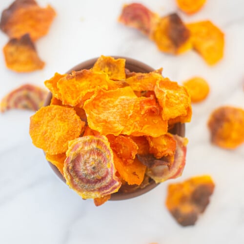 veggie treats for dog in a bowl on a white marble countertop.