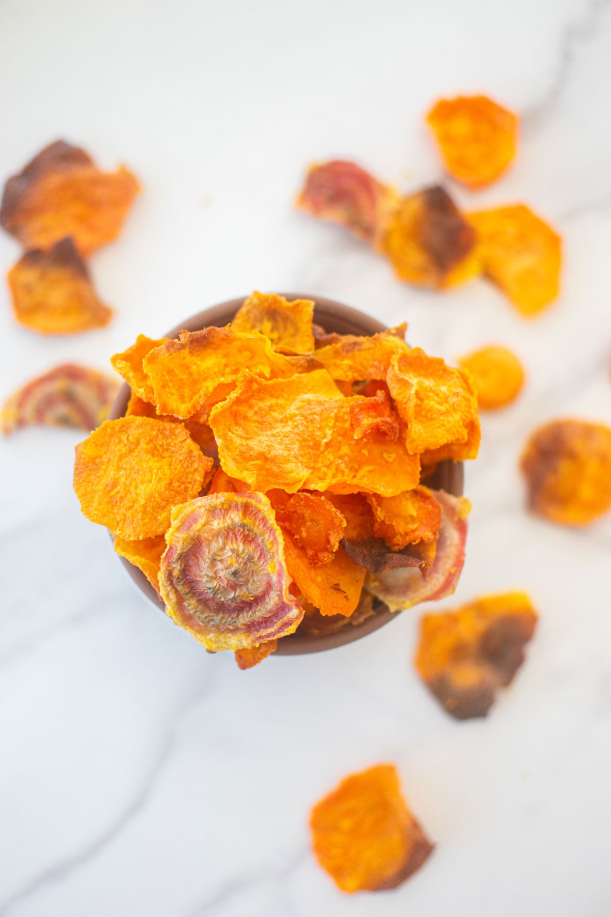 veggie treats for dog in a bowl on a white marble countertop.