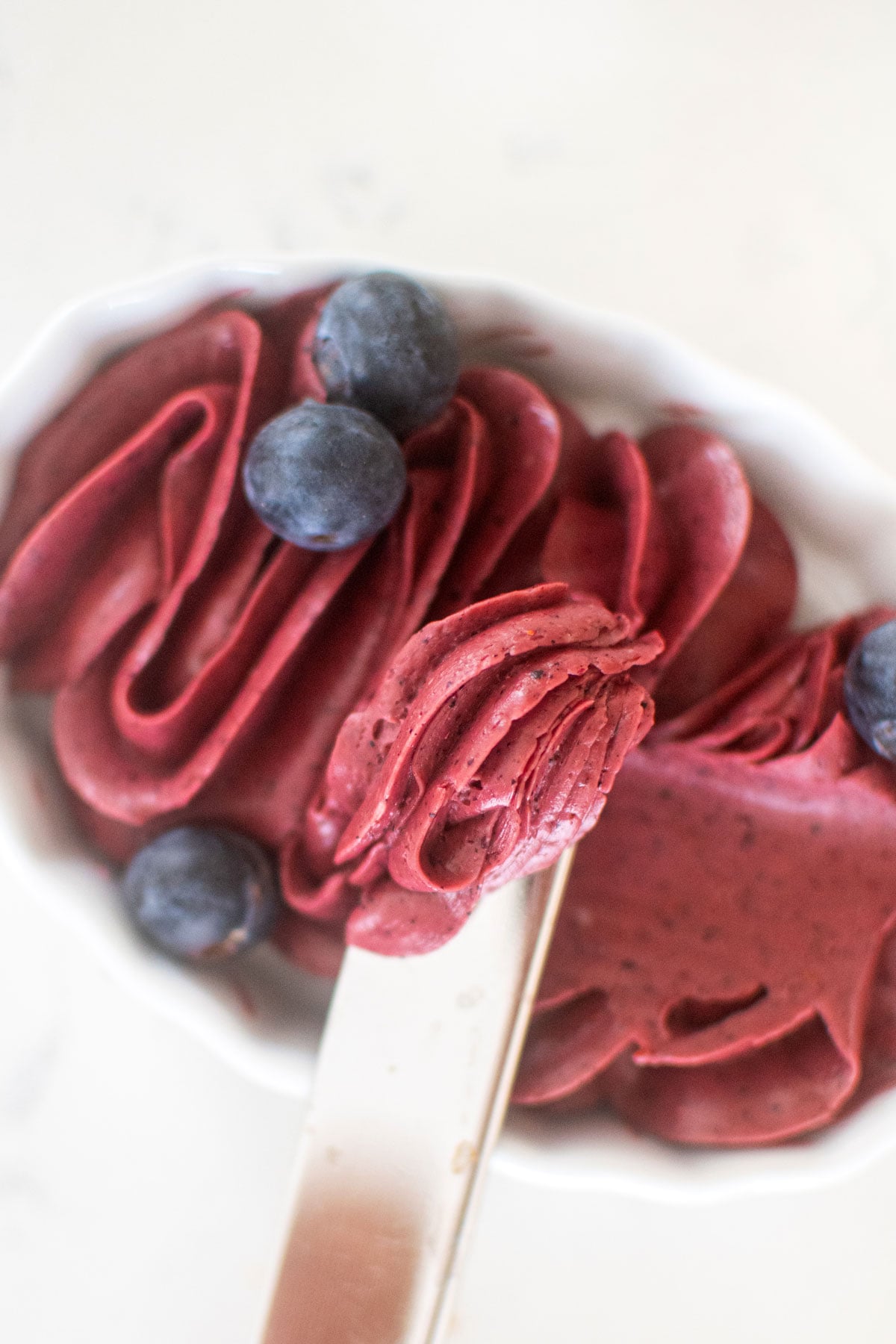 blueberry butter spread in a white dish with a butter knife.