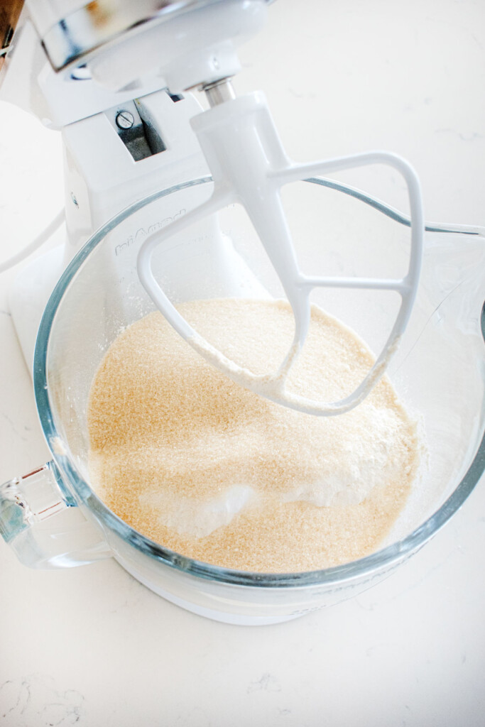ingredients for lemon sheet cake in a glass mixing bowl on a white marble counter.