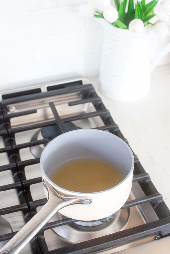 simple syrup being made in a small pot on the stovetop.