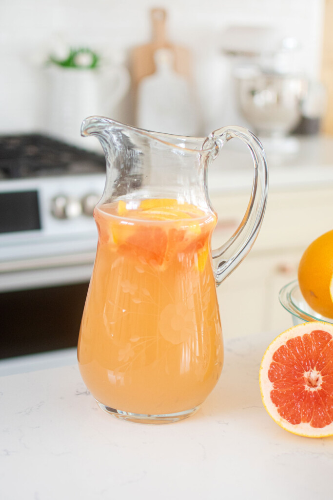 organic pink grapefruit juice in a glass pitcher on the kitchen countertop.