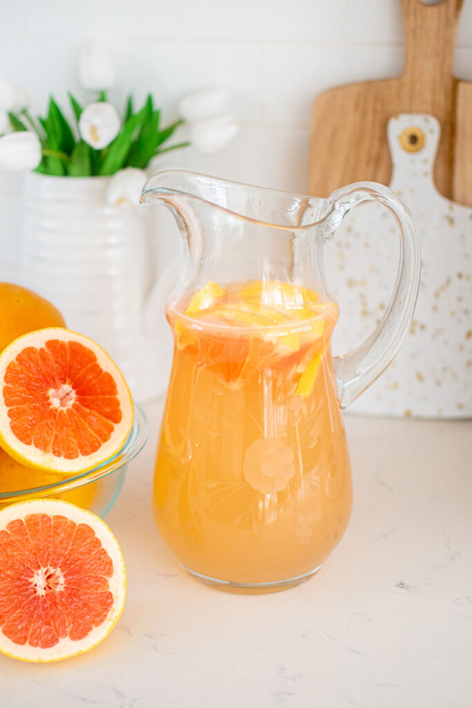 organic pink grapefruit juice in a glass pitcher on the kitchen countertop.