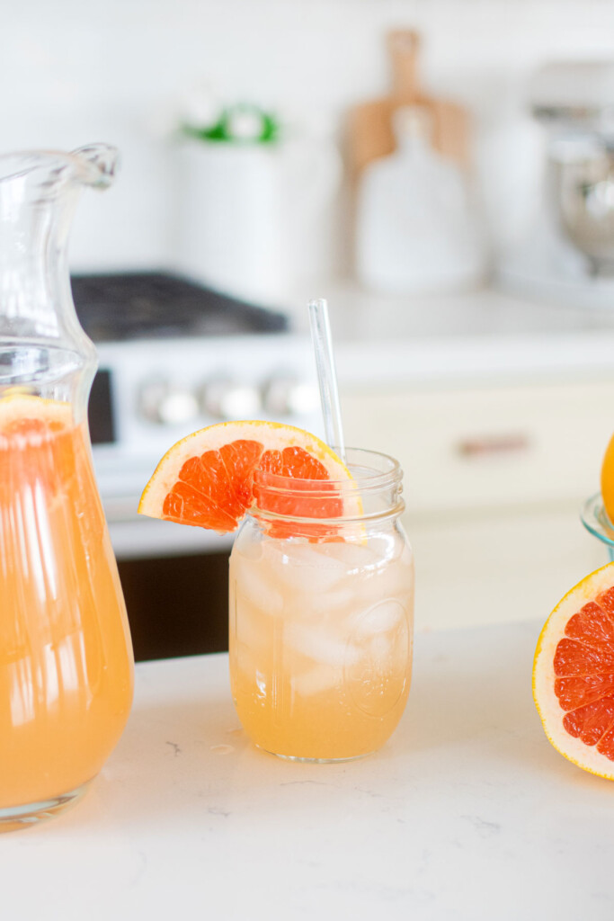 organic pink grapefruit juice in a glass on the kitchen countertop.