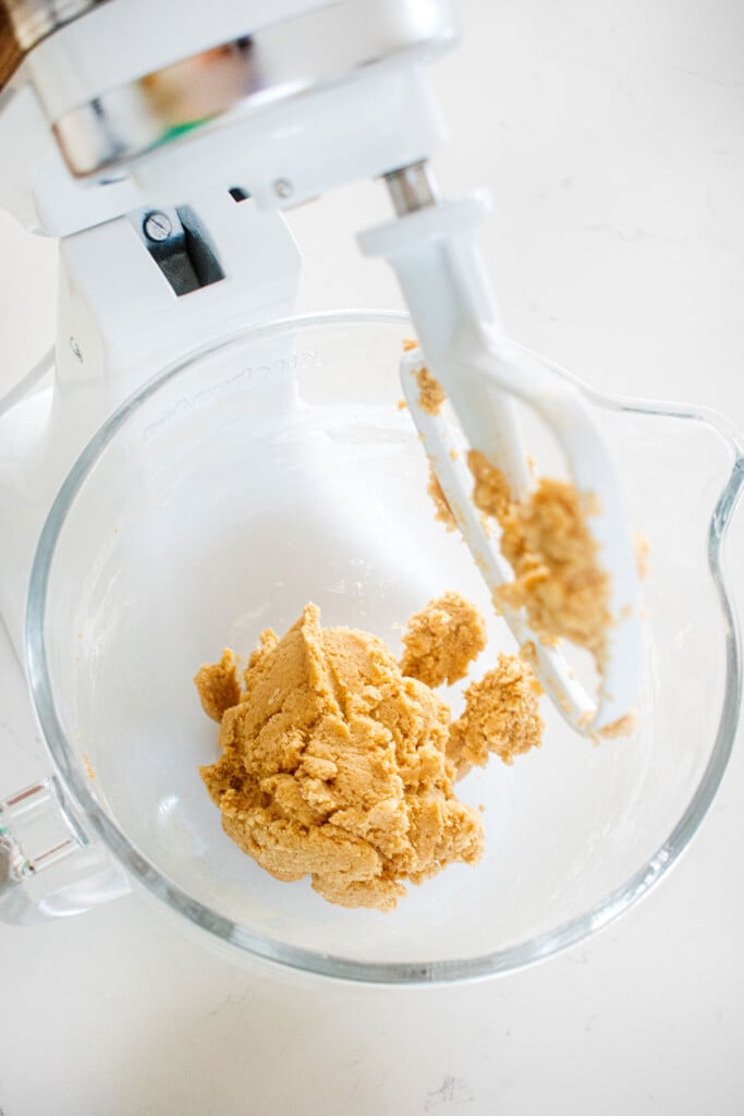 vanilla sea salt chocolate chip cookie dough in a glass mixing bowl on a white marble counter.